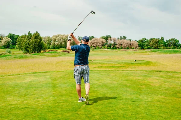 Profesyonel golf sahasında golf oyuncusu. Golf sopasıyla vuruşan golfçü.