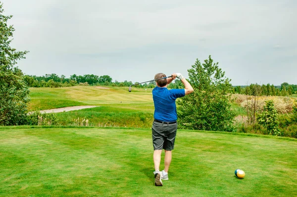 Profesyonel golf sahasında golf oyuncusu. Golf sopasıyla vuruşan golfçü.