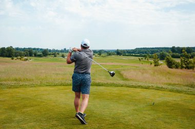 Profesyonel golf sahasında erkek golfçü. Golf sopasıyla vuruşan golfçü.