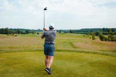 Profesyonel golf sahasında erkek golfçü. Golf sopasıyla vuruşan golfçü.