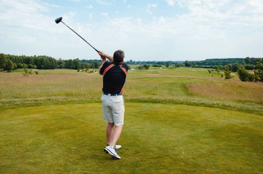 Profesyonel golf sahasında erkek golfçü. Golf sopasıyla vuruşan golfçü.