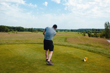 Profesyonel golf sahasında erkek golfçü. Golf sopasıyla vuruşan golfçü.