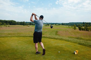 Profesyonel golf sahasında erkek golfçü. Golf sopasıyla vuruşan golfçü.