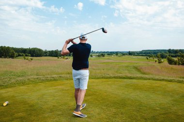 Profesyonel golf sahasında erkek golfçü. Golf sopasıyla vuruşan golfçü.