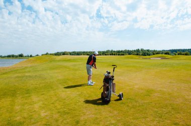 Profesyonel golf sahasında erkek golfçü. Golf sopasıyla vuruşan golfçü.