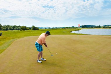 Profesyonel golf sahasında erkek golfçü. Golf sopasıyla vuruşan golfçü.