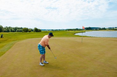 Profesyonel golf sahasında erkek golfçü. Golf sopasıyla vuruşan golfçü.