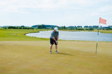 Profesyonel golf sahasında erkek golfçü. Golf sopasıyla vuruşan golfçü.