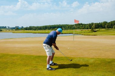 Profesyonel golf sahasında erkek golfçü. Golf sopasıyla vuruşan golfçü.