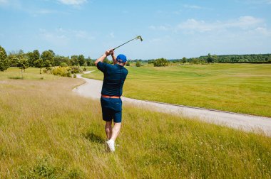 Profesyonel golf sahasında erkek golfçü. Golf sopasıyla vuruşan golfçü.