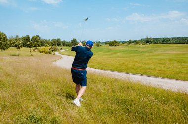 Profesyonel golf sahasında erkek golfçü. Golf sopasıyla vuruşan golfçü.