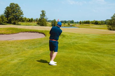 Profesyonel golf sahasında erkek golfçü. Golf sopasıyla vuruşan golfçü.
