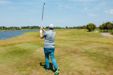 Profesyonel golf sahasında erkek golfçü. Golf sopasıyla vuruşan golfçü.