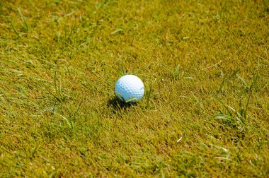 Golf topu çimlerin üzerinde.