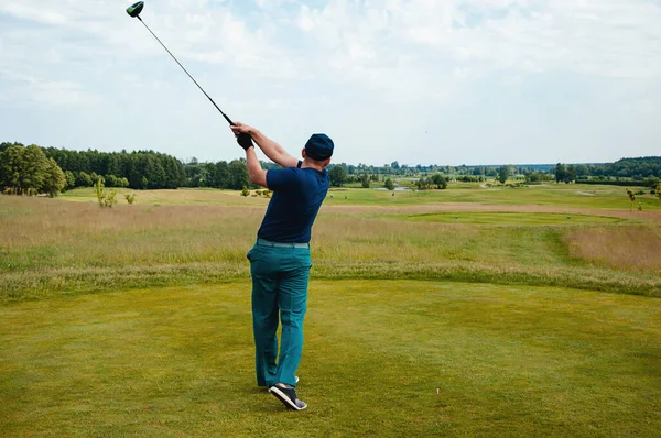 Male golf player on professional golf course. Golfer with golf club taking a shot