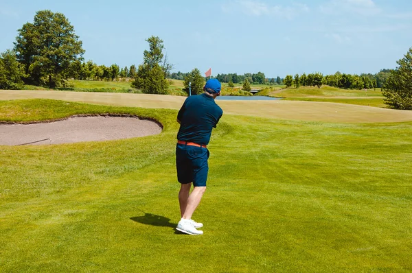 Profesyonel golf sahasında erkek golfçü. Golf sopasıyla vuruşan golfçü.