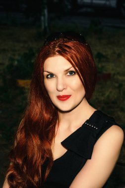 Güzel kız kızıl saçlıdır. Sokaktaki portre