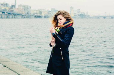 Kış gezintisinde elinde bir buket gülle güzel, genç, neşeli bir sarışın. Sevgililer Günü