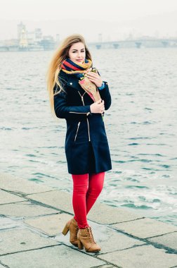 Kış gezintisinde elinde bir buket gülle güzel, genç, neşeli bir sarışın. Sevgililer Günü