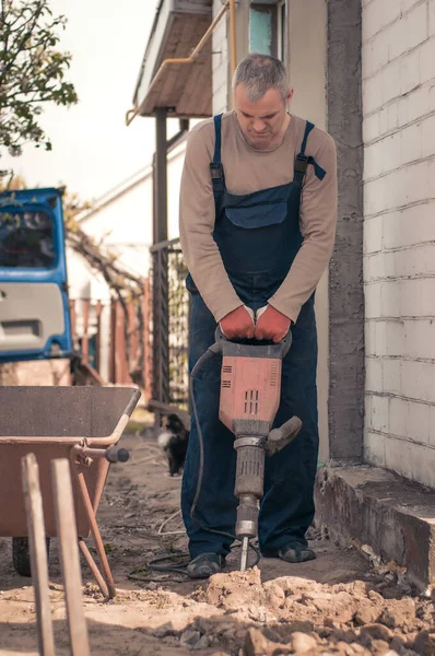 A man builder makes repairs around the house. Hammer, sparks.