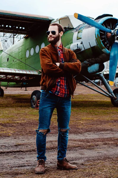 ヴィンテージ航空機を背景に若いパイロットを髭を生やした — ストック写真