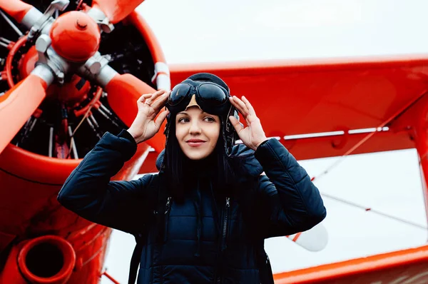 飛行機の前で若い美しい女性パイロットの肖像画 — ストック写真