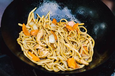 Tavuk, sebze ve fasulye filizi ile karıştırılmış Çin eriştesi. Yemek pişirme süreci