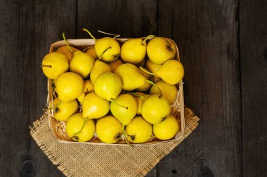 Tahta bir sepetin içindeki sarı taze armutlar.
