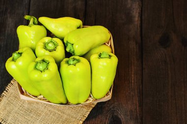 Tahta bir sepetin içindeki yeşil biberler.