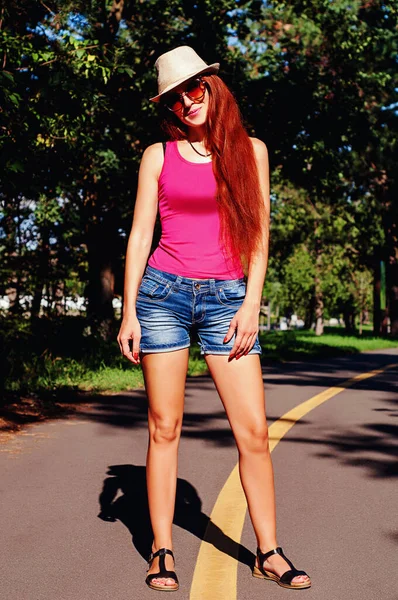 夏の肖像画 公園の赤い髪の少女が歩道に立っている — ストック写真