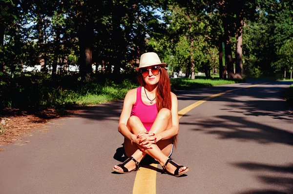 夏の肖像画 公園の赤い髪の少女が歩道に座っている — ストック写真