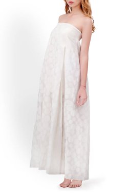 Seçkin kız model, stüdyoda izole edilmiş bir arka planda giysilerini ve ayakkabılarını gösteriyor.