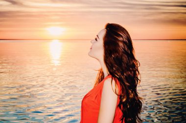 Kiev Denizi akşamında, uzun kırmızı elbiseli güzel hamile esmer, Temmuz 2015