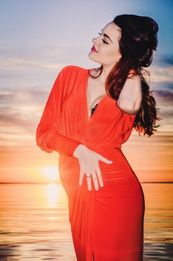 Kiev Denizi akşamında, uzun kırmızı elbiseli güzel hamile esmer, Temmuz 2015