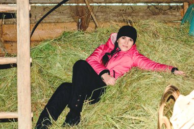 Kışlık kayak kıyafetli kızıl saçlı bir kız samanlıkta samanlıkta