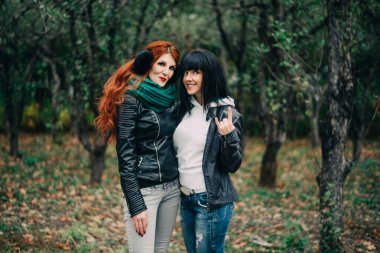 Sonbaharda şehre kuru yapraklar atan komik kız arkadaşlar.