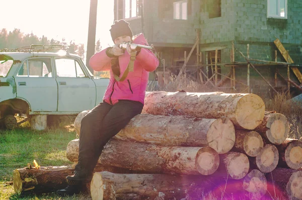 Ein Mädchen Schießt Mit Einer Waffe Auf Einem Verdrehten Baumstamm — Stockfoto