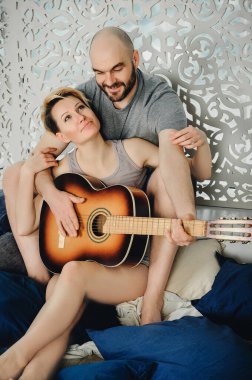 Sakallı bir adam ve sarışın bir kız yerde yastıkların arasında oturuyorlar. Gitar, duygular, aşk. Aşk hikayesi..