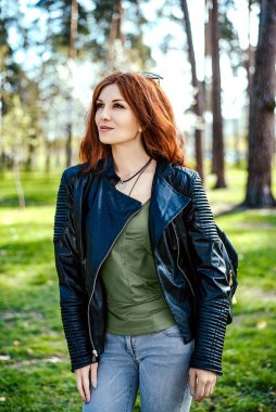 Sonbaharda ya da bahar parkında gülümseyen kızıl saçlı kız.