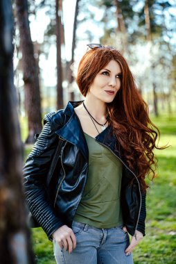 Sonbaharda ya da bahar parkında gülümseyen kızıl saçlı kız.