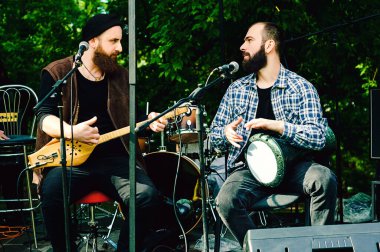 Panduri olarak bilinen geleneksel Gürcistan müzik enstrümanı. Georgia 'lı erkekler enstrümanlarla sahnede çalıp şarkı söylüyorlar.