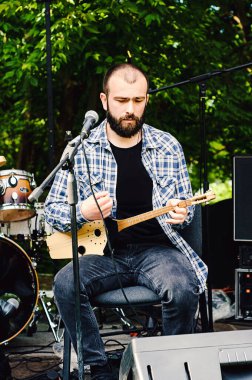 Panduri olarak bilinen geleneksel Gürcistan müzik enstrümanı. Georgia 'lı erkekler enstrümanlarla sahnede çalıp şarkı söylüyorlar.