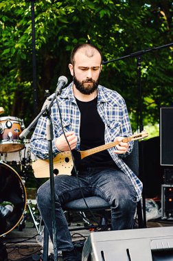 Panduri olarak bilinen geleneksel Gürcistan müzik enstrümanı. Georgia 'lı erkekler enstrümanlarla sahnede çalıp şarkı söylüyorlar.