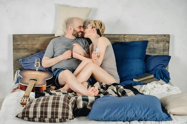 Tipo Com Barba Uma Loira Está Sentado Cama Guitarra Livro — Fotografia de Stock