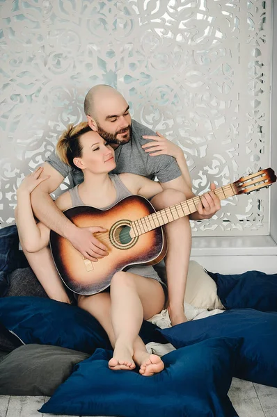 一个留着胡子的男人和一个金发姑娘坐在枕头中间的地板上 爱情故事 — 图库照片