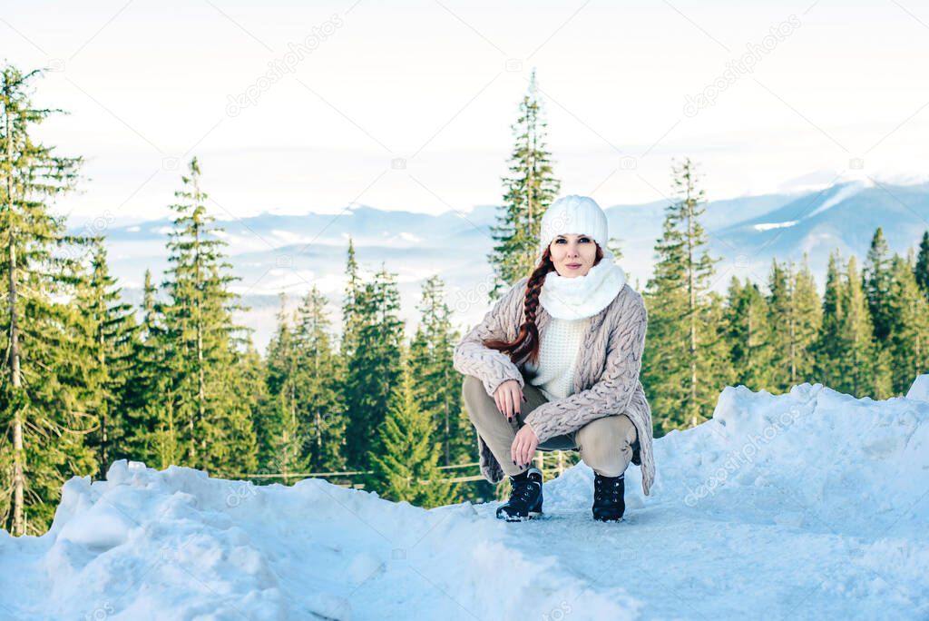 Redheaded girl in winter with a snowy mountain in the background
