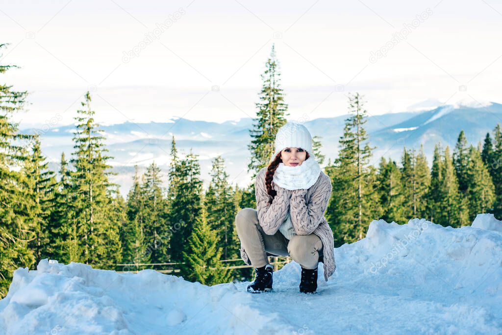 Redheaded girl in winter with a snowy mountain in the background