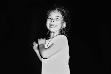 Siyah beyaz gülümseyen küçük kızın portresi.