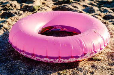 Çocukların pembe can simidi kumsalda kumsalda.