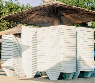 Akşamları, kumsalda güneşli bir yerde, sazdan yapılmış büyük bir şemsiyenin altında..